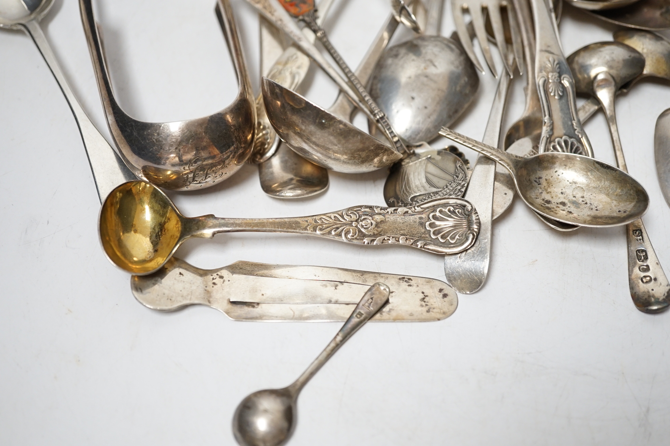 A small quantity of assorted 19th century and later silver flatware, two white metal spoons and a Victorian 'Rum' wine label, 18.2oz.